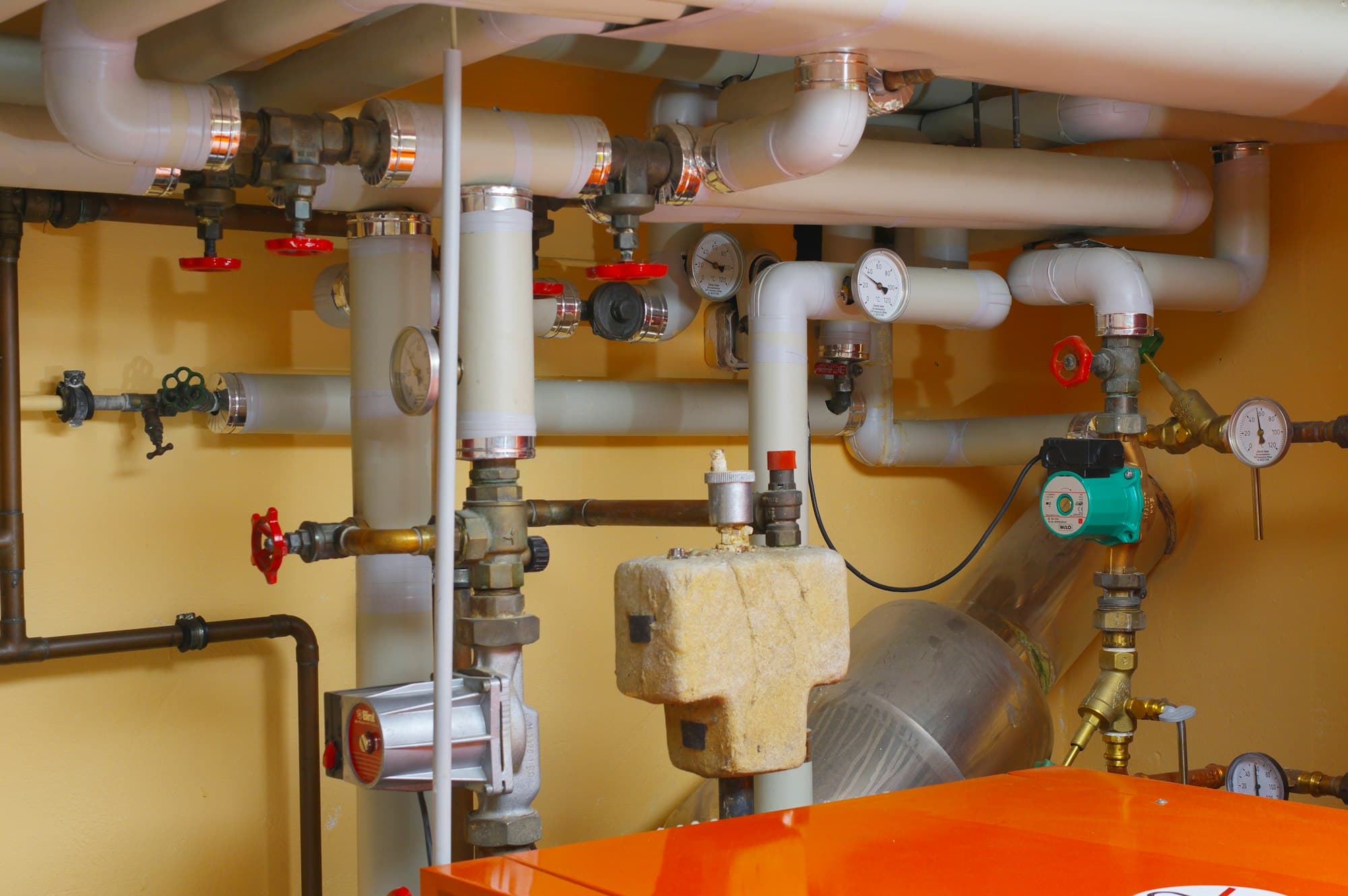 Heizungsraum mit Rohren, Pumpen und Ventilen